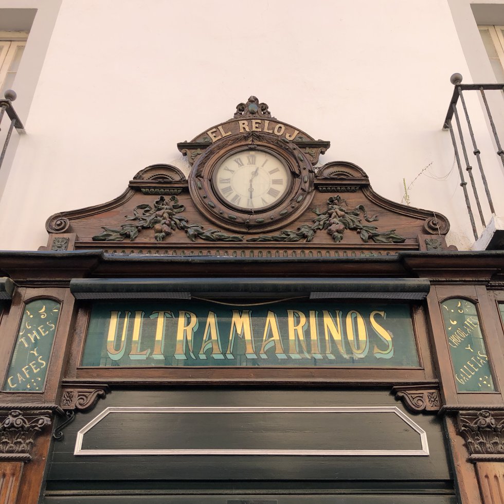 Panneau historique « ULTRAMARINS » sur la façade d’El Reloj (Calle Arfe, Séville), faisant partie de l’identité graphique urbaine.