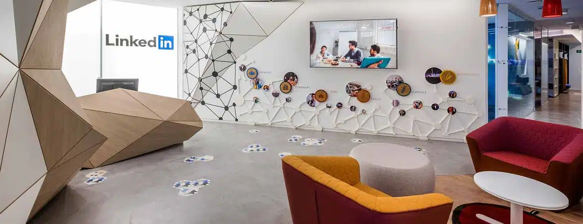 Accueil et espace commun du projet LinkedIn avec design d’entreprise, comptoir géométrique, mobilier d’attente et éléments graphiques intégrés au mur.